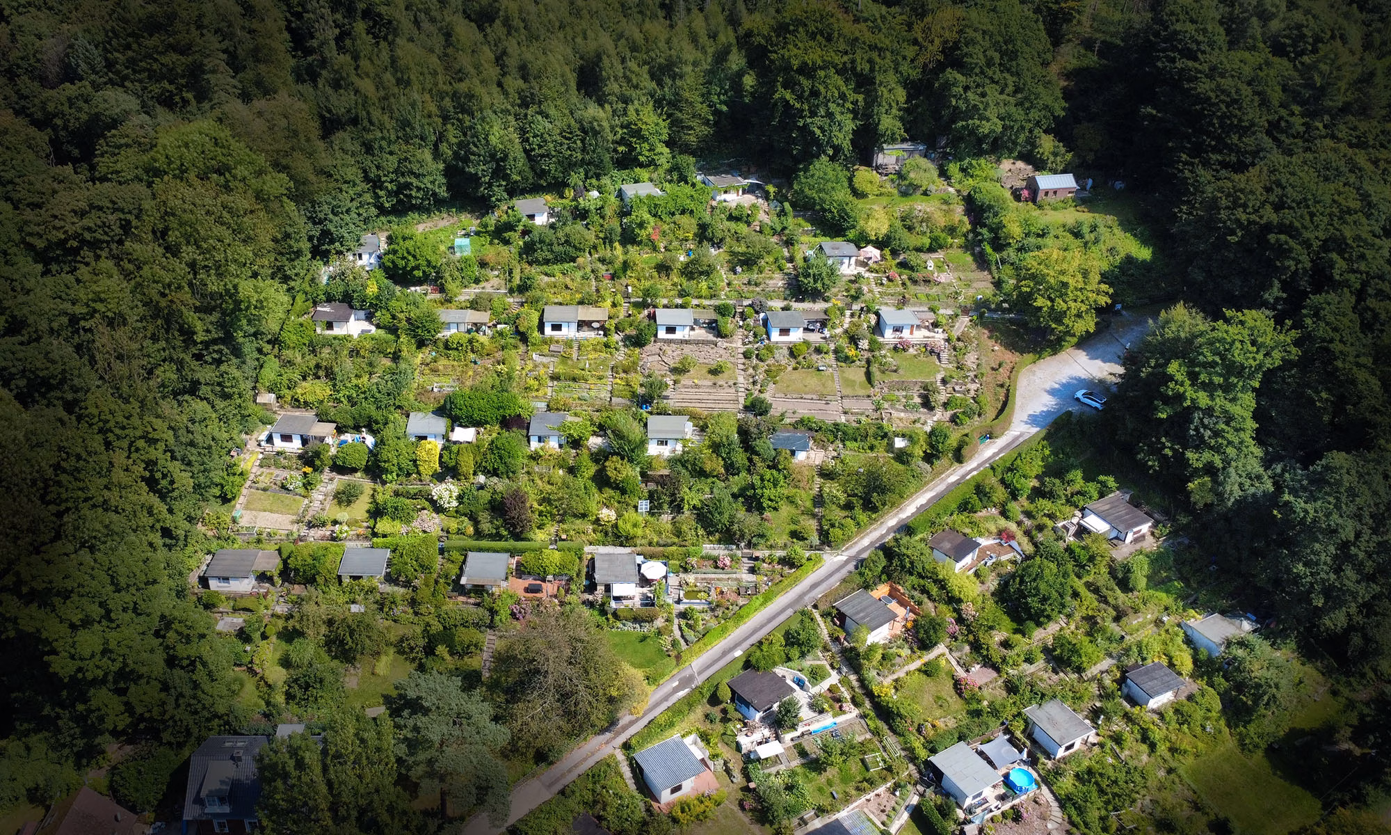 Drohnenaufnahme: Die Kleinartenanlage mit 33 Gärten ungeben von Wald